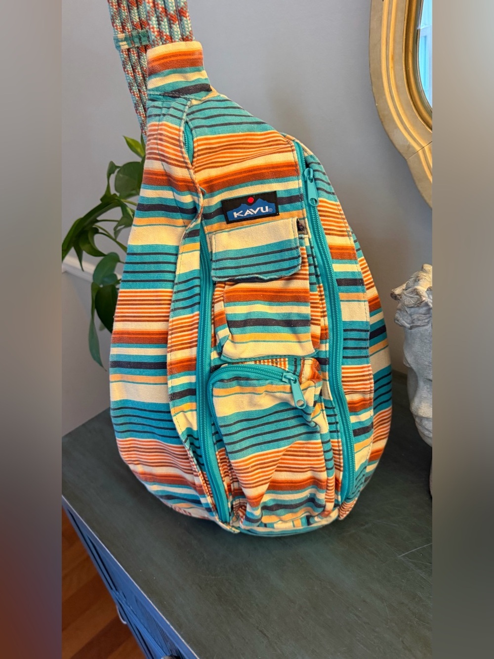 KAVU Rope Sling bag with vibrant multicolored stripe pattern and rope shoulder